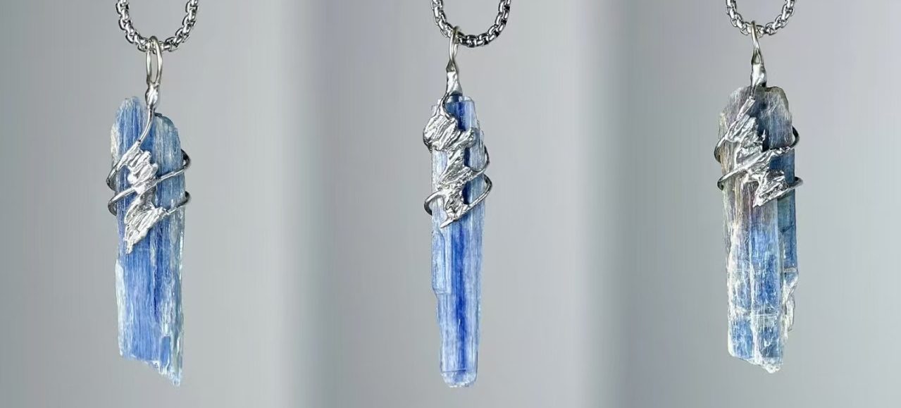 Natural blue kyanite pendant necklace with hand-soldered tin wire design, resembling ocean waves and glaciers.